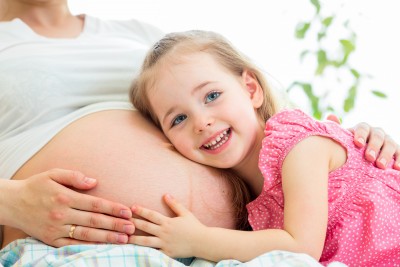 Happy Kid Girl Hugging Pregnant Mother's Belly