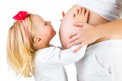Pregnant woman with 2 yo daughter on white