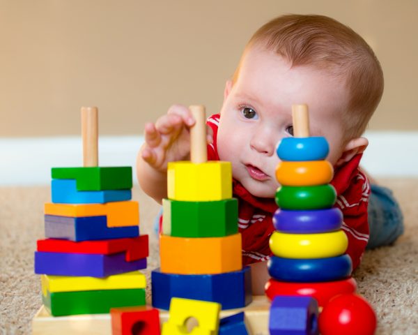 Baby boy playing with stacking learning toy