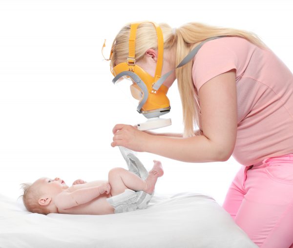 Diaper changing - hygiene concept. Young mother solving an smell